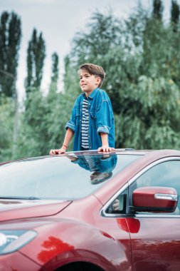 boy peering out of sun roof clipart