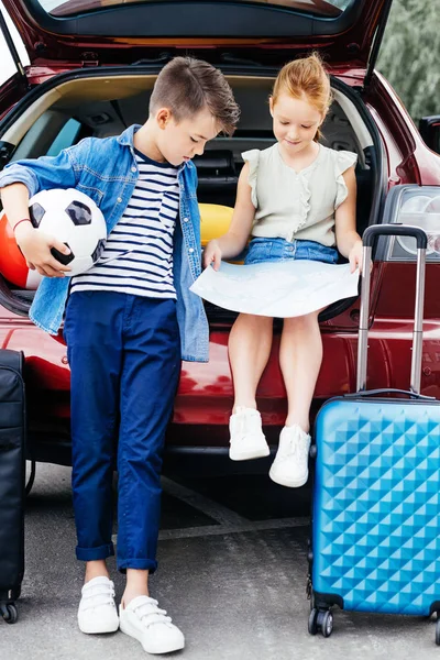 Брат и сестра в багажнике автомобиля — стоковое фото