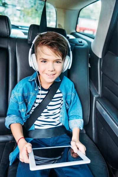 Jongen met tablet luisteren muziek in auto — Stockfoto