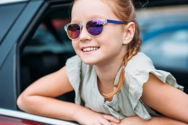 Girl looking out car window — Stock Photo, Image