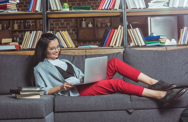 Девушка с ноутбука в библиотеке — стоковое фото
