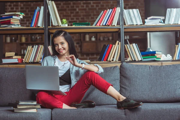 dizüstü bilgisayar ve kitap okuyan kız