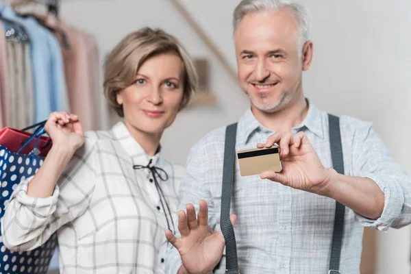 Hombre mostrando tarjeta de crédito en la tienda — Foto de Stock