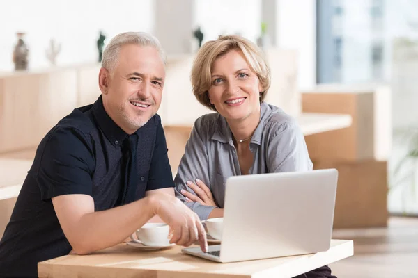 Casal sentado à mesa com laptop — Fotografia de Stock