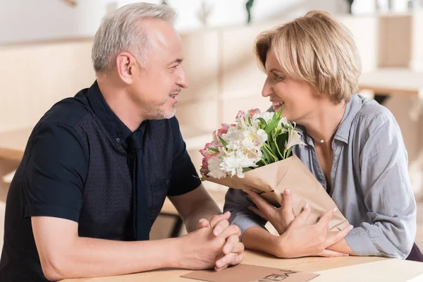 Man presenterar blommor till kvinna — Stockfoto