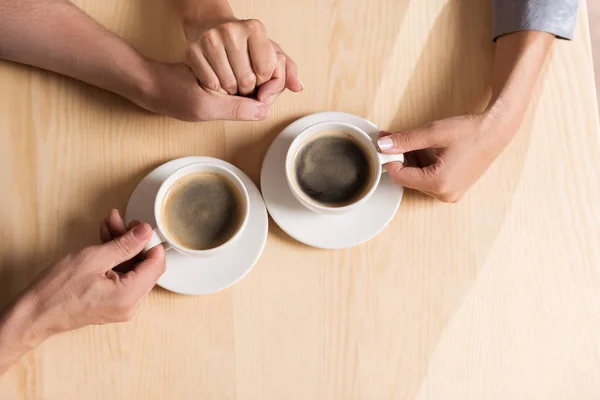 Paret håller händerna och dricka kaffe — Stockfoto