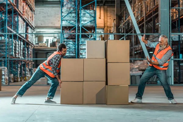 Trabajadores de almacén moviendo cajas — Foto de Stock