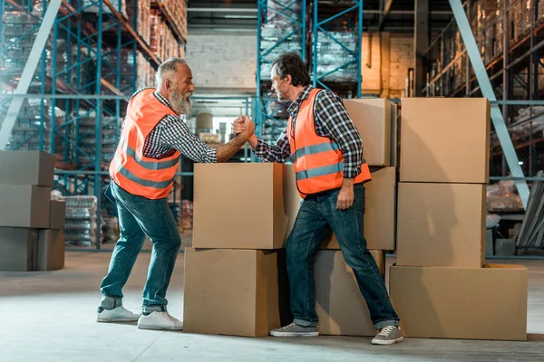 Arm wrestling of warehouse workers — Stock Photo, Image