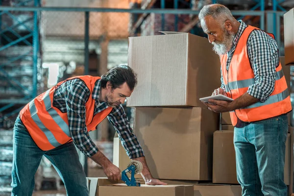 Warehouse workers with digital tablet Stock Picture