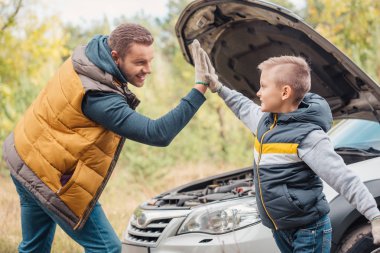 father and son repairing car clipart