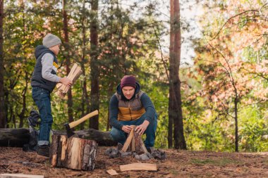 father and son chopping firewood clipart