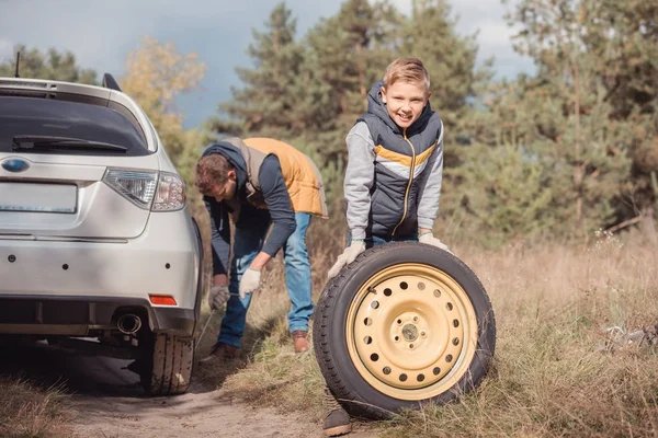 Father and son changing car wheel — Stock Photo, Image