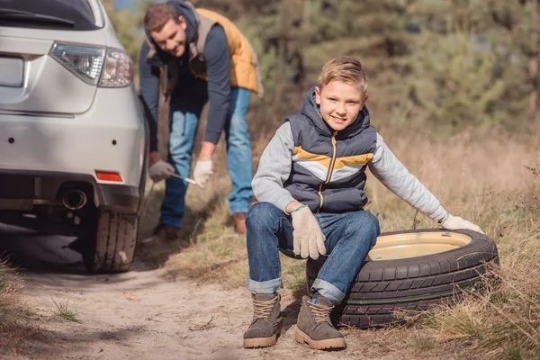 Vater und Sohn wechseln das Autorad — Stockfoto