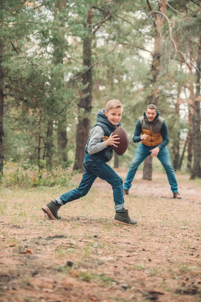 Padre e hijo jugando con pelota en el bosque — Foto de Stock