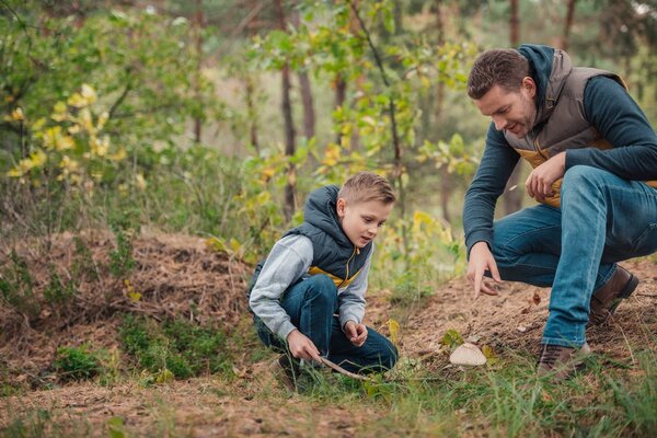 father and son looking at mushroom