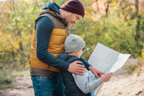 Vader en zoon met kaart in bos — Stockfoto