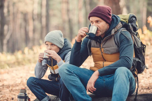 Father and son drinking tea in forest — Stock Photo, Image