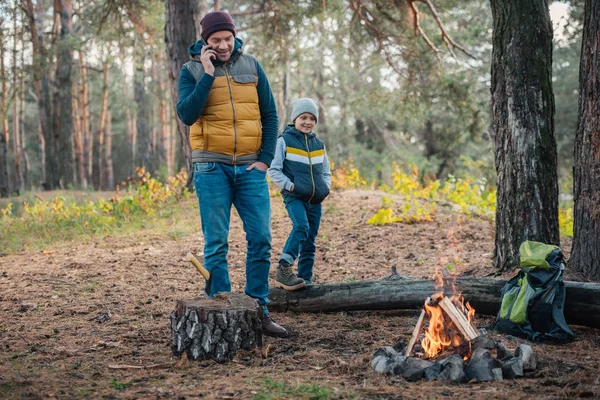 Padre con smartphone e figlio nella foresta — Foto Stock