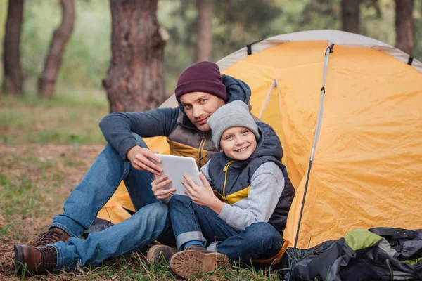 Pai e filho com tablet digital na floresta — Fotografia de Stock