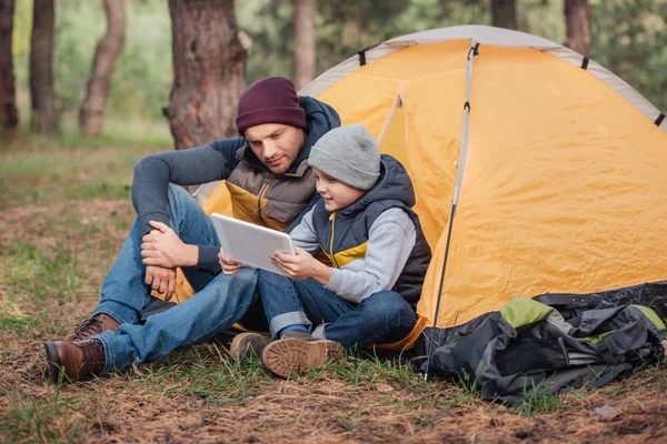 Father and son with digital tablet in forest — Stock Photo, Image