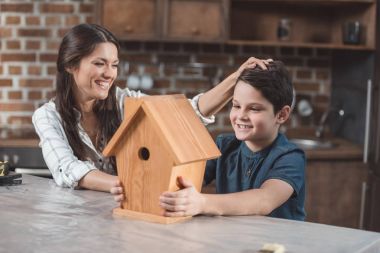 Proud son and mother with birdhouse clipart