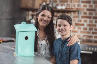 Son and mother with wooden birdhouse clipart
