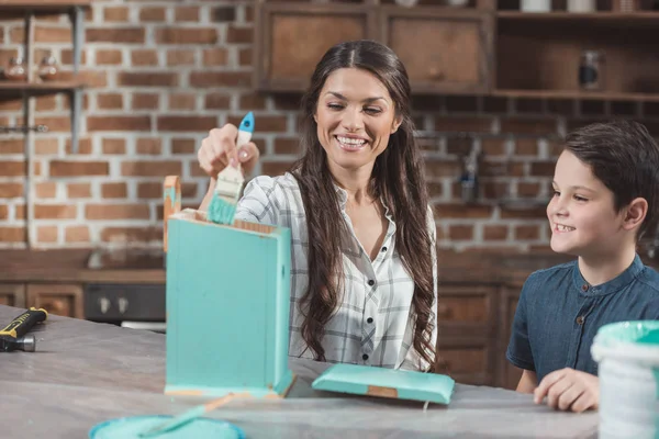Mother and son painting birdhouse — Stock Photo, Image
