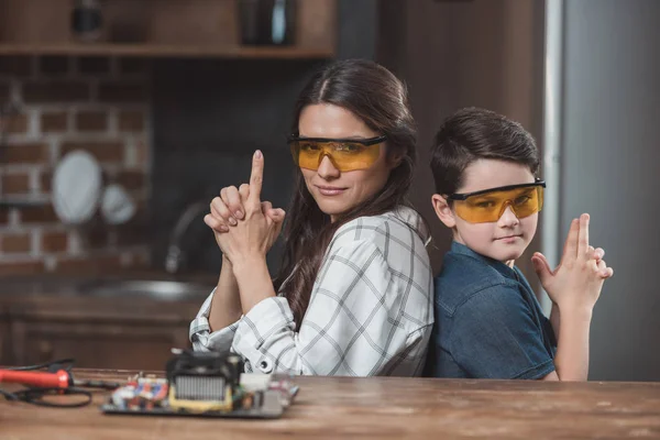 Mãe e filho posando com as armas dos dedos — Fotografia de Stock