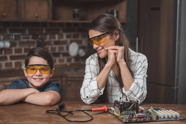 Mother and son with computer motherboard