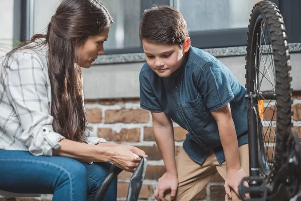 Mother and son fixing bicycle tire — Stock Photo, Image