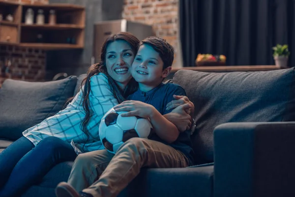 Hugging mother and son watching soccer — Stock Photo, Image