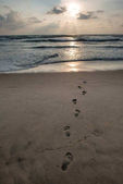 kroky na písečné pláži