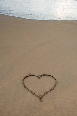 Kalp şekli işareti kum üzerinde