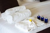 zahrnuty ručníky a župan na posteli