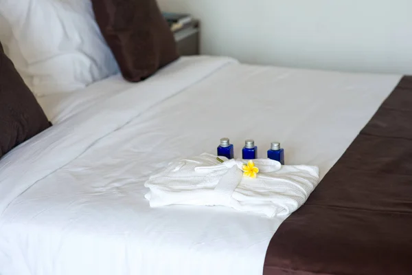 バスローブを着て、ベッドとバスルームのアメニティ — ストック写真
