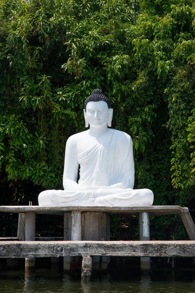 Estatua de buddha en la orilla del río — Foto de Stock