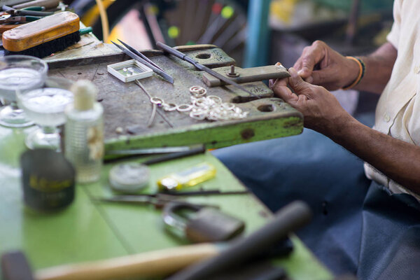 Cropped shot of oriental jewelry master making rings at sri lanka manufacture