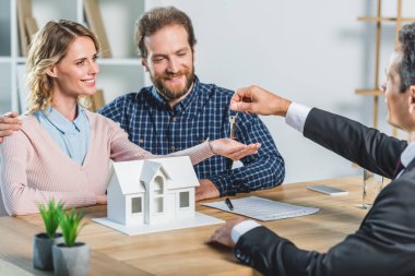 couple getting keys from realtor clipart