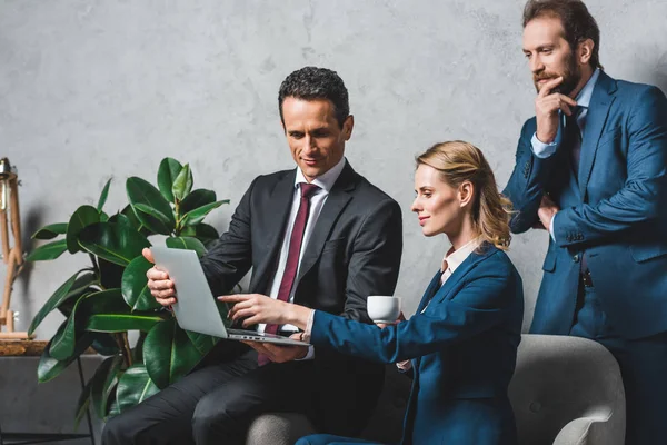 Colleagues using laptop together — Stock Photo, Image