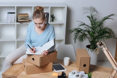 evde office çalışırken not defterinde notlar yapma konsantre girişimci portresi