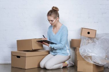 evde çalışırken not defterinde notlar yapma online dükkan sahibi genç konsantre