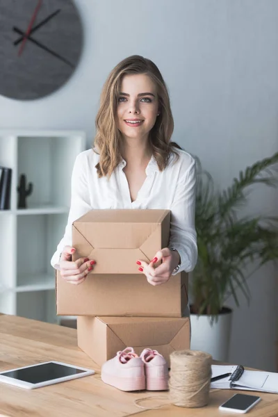 Retrato Sonriente Mujer Negocios Autónoma Con Paquetes Mirando Cámara Oficina — Foto de Stock