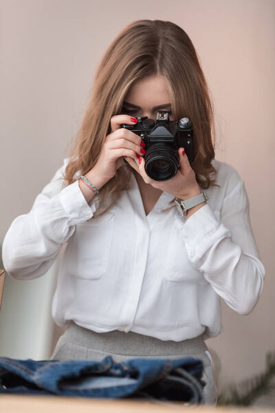 obscured view of self-employed businesswoman taking picture of products for customers at home office