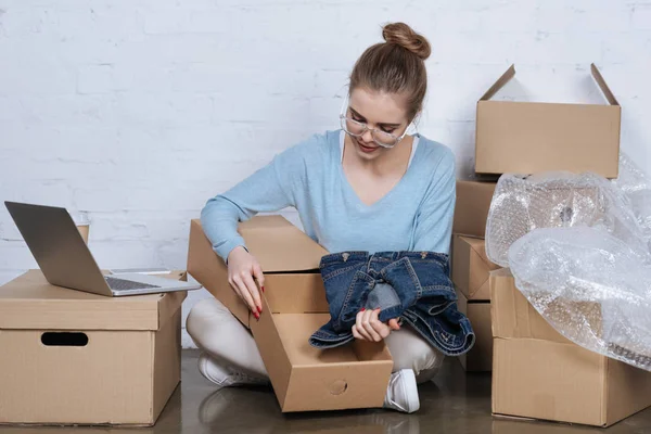 Young Entrepreneur Putting Denim Jacket Cardboard Box While Packing Products — Stock Photo, Image