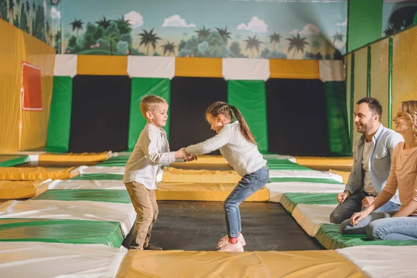 Recortado Disparo Sonrientes Padres Mirando Los Niños Tomados Mano Saltando — Foto de Stock