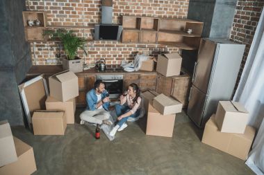 mutlu genç çiftin şarap içme ve tehcir yeni evde kutlama yüksek açılı görünüş