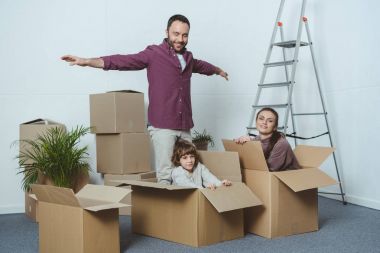 happy family having fun with cardboard boxes while moving home clipart
