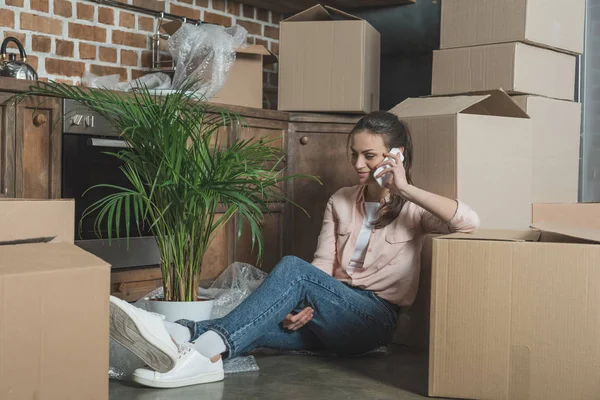 Smiling Young Woman Talking Smartphone While Sitting Cardboard Boxes New — Free Stock Photo