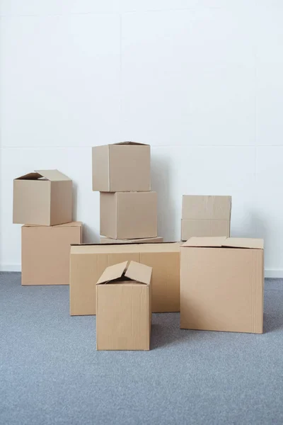 stacked cardboard boxes in empty room during relocation
