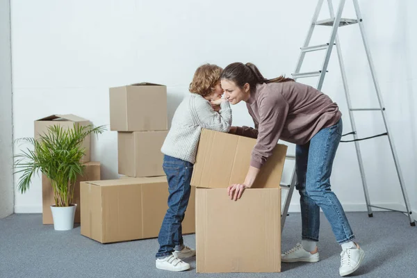Liten Pojke Viskar Något Till Mor Medan Packning Kartonger Tillsammans — Stockfoto